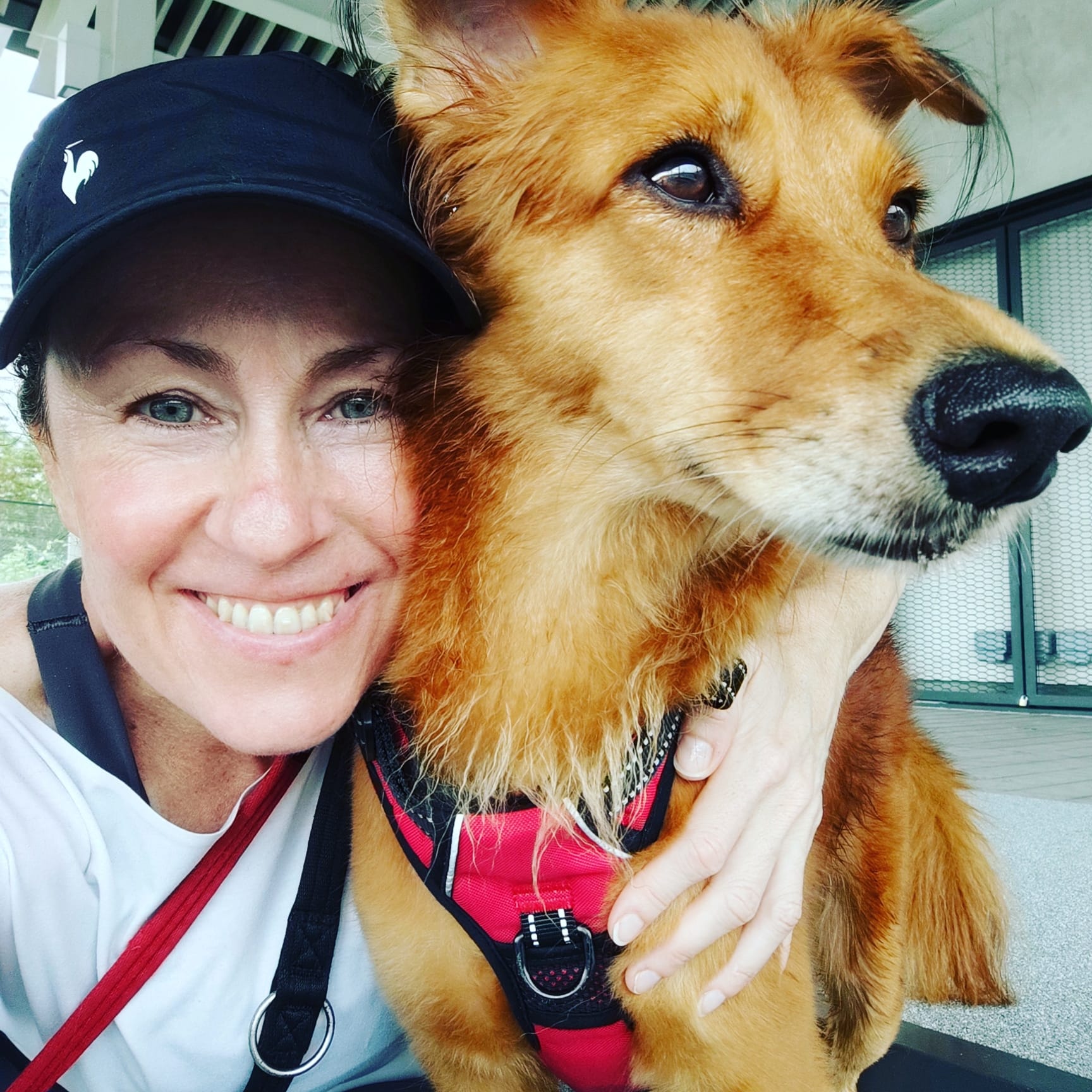 Andrea, Founder of Happi Kids, smiling with her dog